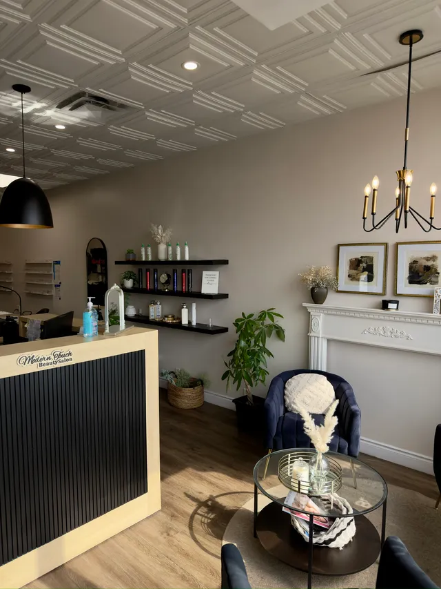 Reception desk at Modern Touch, fronted with black slat panelling under a coffered ceiling